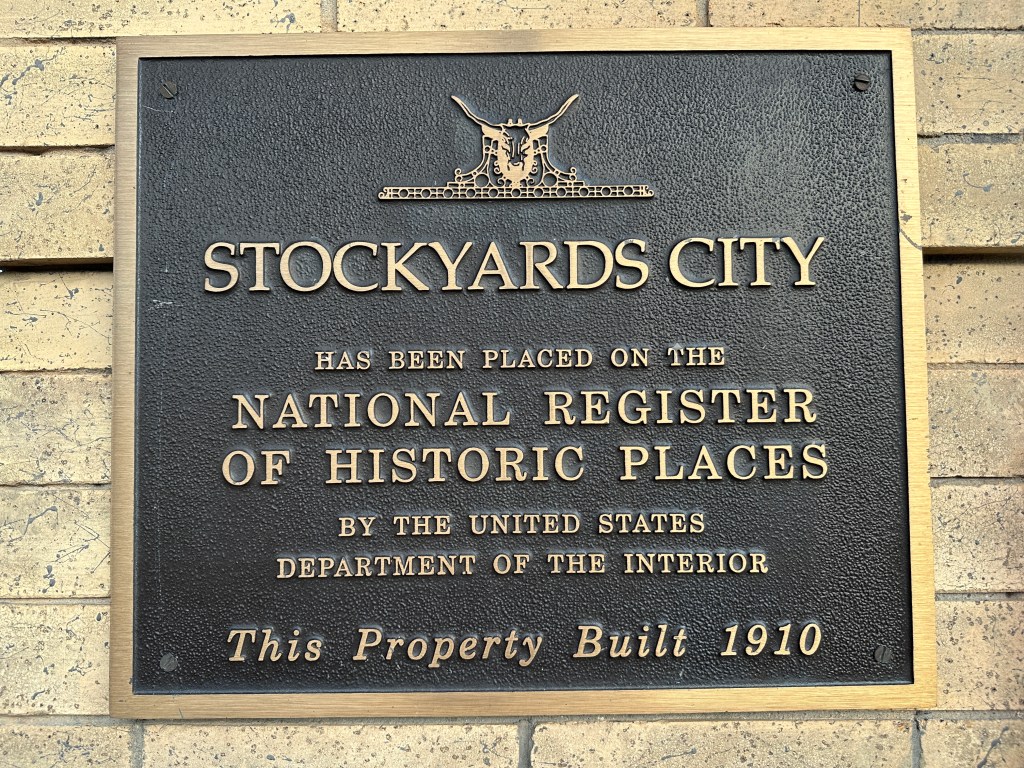 Plaque commemorating Stockyards City, indicating it has been placed on the National Register of Historic Places by the U.S. Department of the Interior, built in 1910.