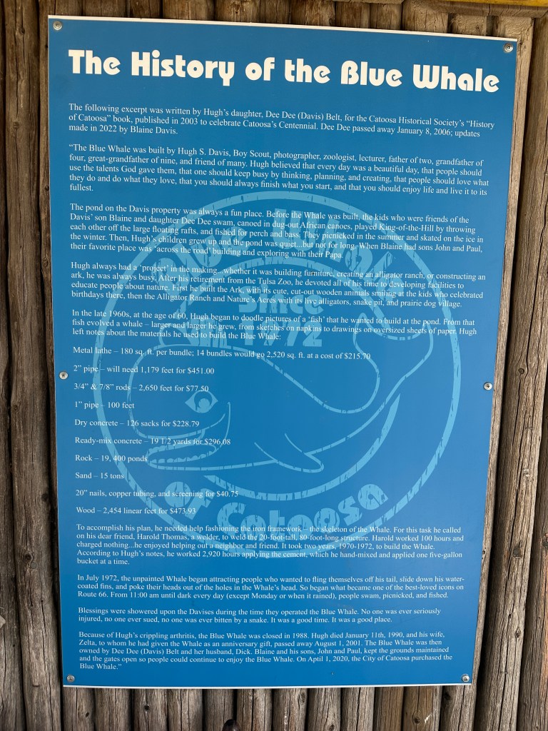 Information plaque detailing the history of the Blue Whale in Catoosa, Oklahoma, including its construction by Hugh S. Davis and its significance for the community.
