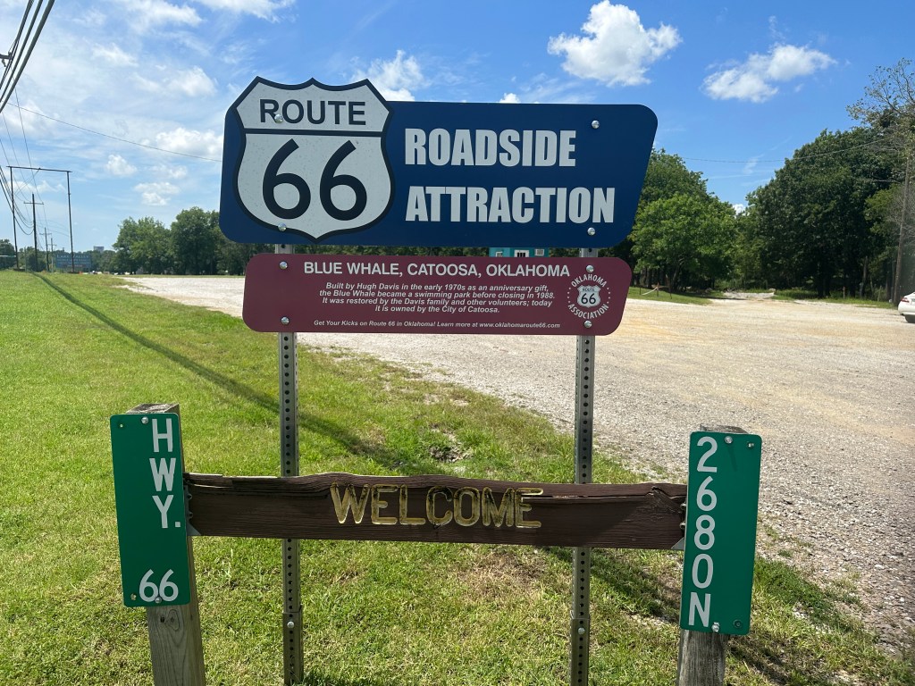 Sign indicating the Blue Whale roadside attraction located in Catoosa, Oklahoma, along Route 66, featuring details about the attraction's history.
