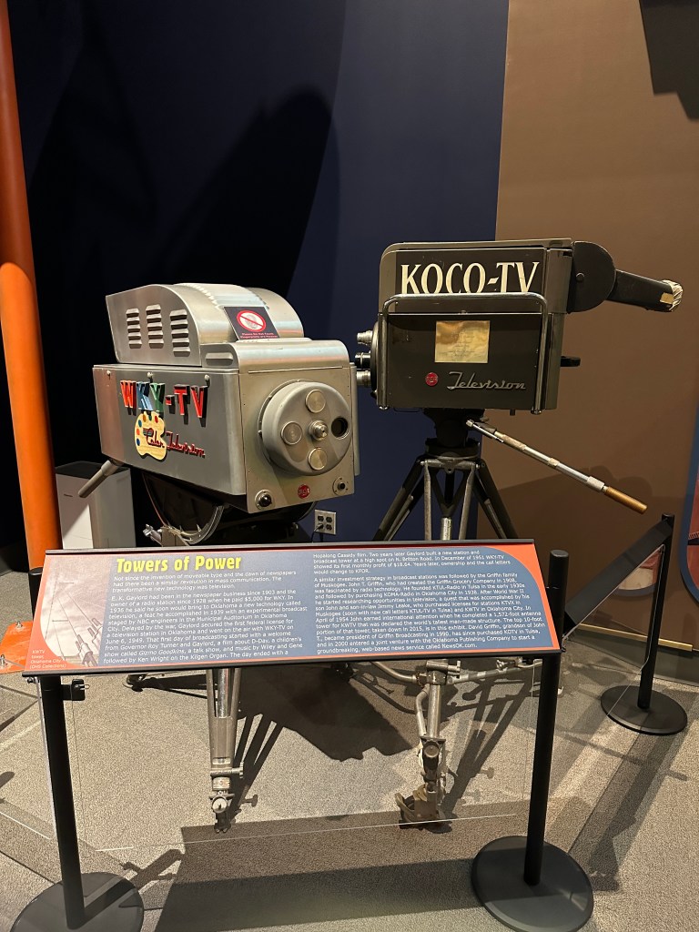 Historic television cameras on display at the Oklahoma History Center, featuring WKY-TV and KOCO-TV models, with an informative panel titled 'Towers of Power.'