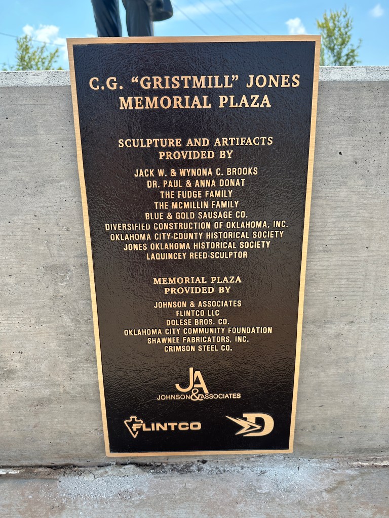 Bronze plaque commemorating the C.G. 'Gristmill' Jones Memorial Plaza, listing contributors and organizations involved in the project.
