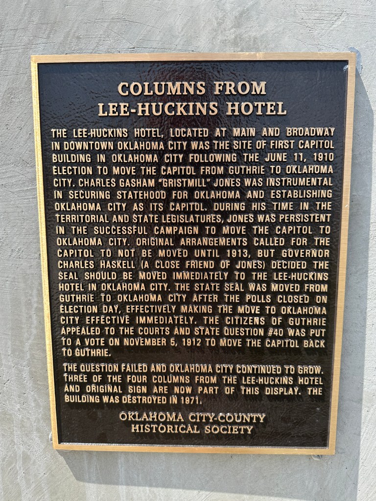 Plaque detailing the history of the columns from the Lee-Huckins Hotel in Oklahoma City, highlighting its significance as the site of the first Capitol building following the 1910 election.