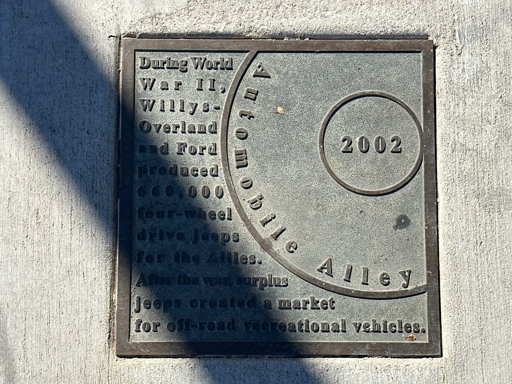 Historic marker plaque commemorating the production of four-wheel drive jeeps by Willys-Overland and Ford during World War II, located in the Automobile Alley Historic District.