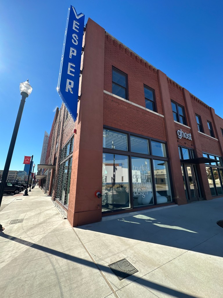 Exterior view of the Vesper building in Automobile Alley, showcasing its prominent sign and modern storefront.