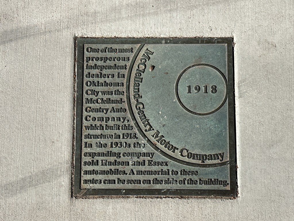 Historic marker plaque for McClelland-Gentry Auto Company from 1918, detailing its significance as an independent dealer in Oklahoma City.