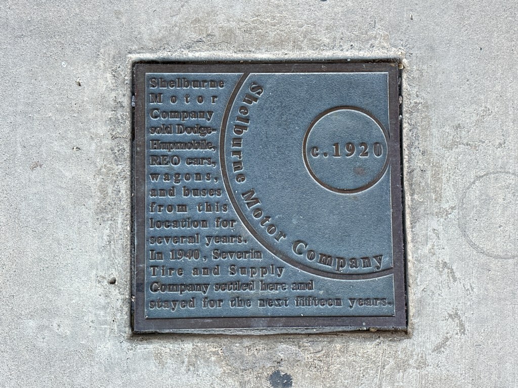Historic marker plaque for Shelburne Motor Company located in Automobile Alley, Oklahoma City. The plaque details the history of the company and its operations.