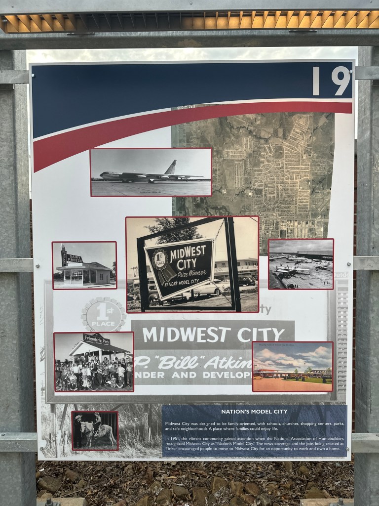Informational sign about Midwest City, featuring images of planes, historical landmarks, and community events.