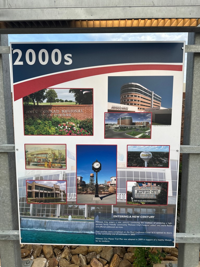 Informational sign depicting key developments in Midwest City during the 2000s, featuring images of local landmarks and facilities.