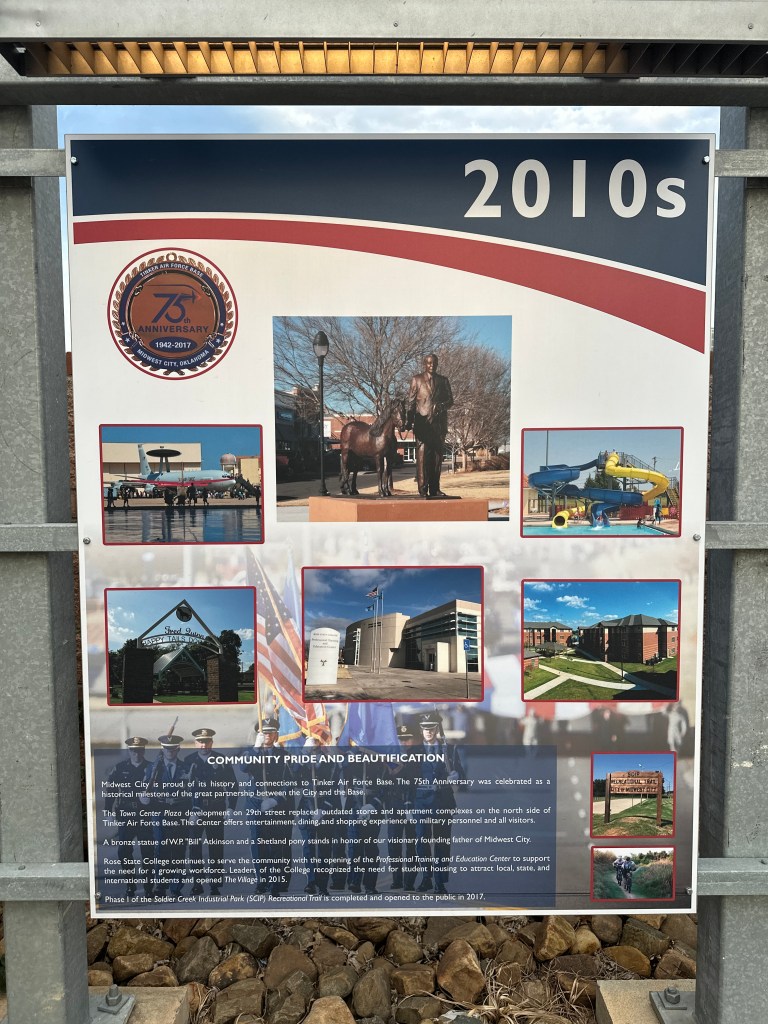 Information sign commemorating the 75th anniversary of Tinker Air Force Base, featuring images of community projects and milestones in Midwest City during the 2010s.