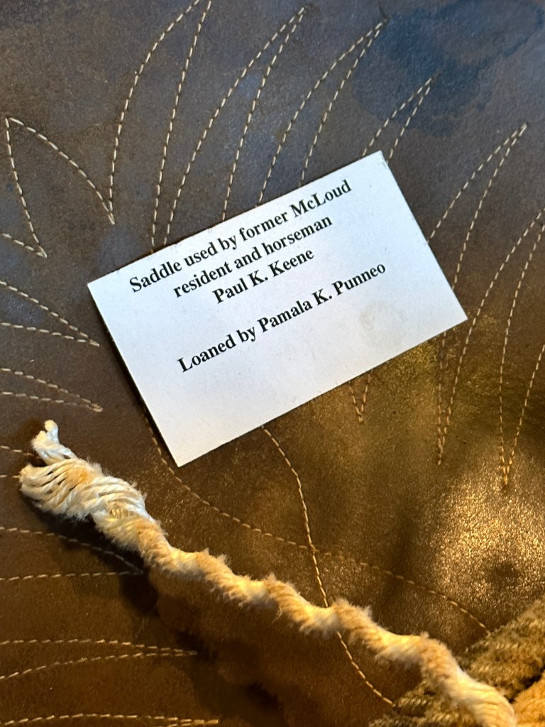 Close-up of a saddle with a label indicating it belonged to Paul K. Keene, a former resident of McLoud, Oklahoma.