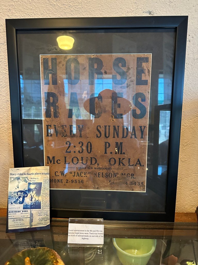 A framed poster advertising horse races in McLoud, Oklahoma, detailing the event schedule and management information.