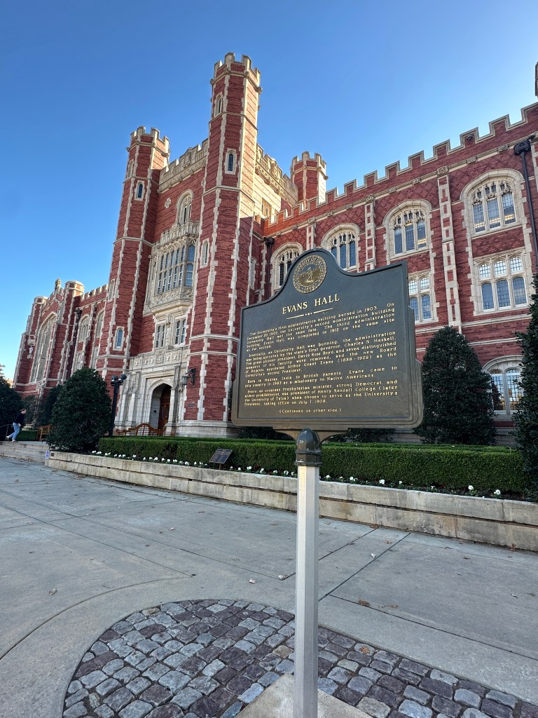 Historic Evans Hall building at the University of Oklahoma with a historical marker in the foreground.