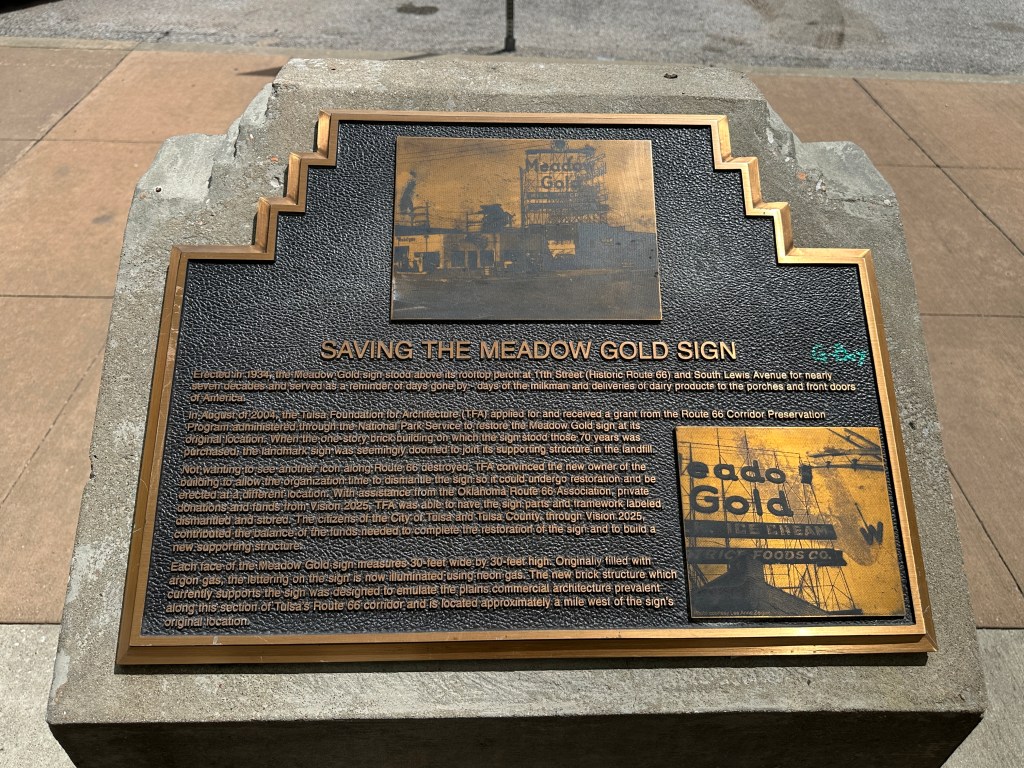 Historic plaque detailing the saving of the Meadow Gold sign in Tulsa, Oklahoma, featuring text about its history and restoration efforts.