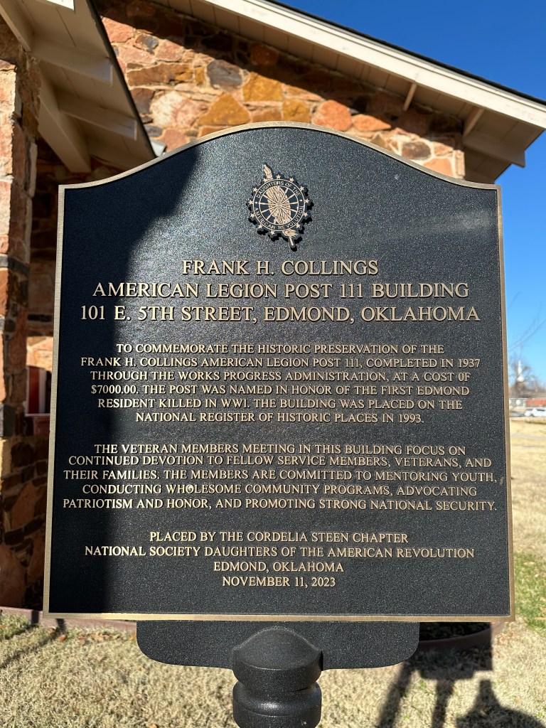 A historical plaque commemorating the Frank H. Collings American Legion Post 111 building located at 101 E. 5th Street, Edmond, Oklahoma. The plaque details the building's construction by the Works Progress Administration in 1937, its dedication to veterans, and its listing on the National Register of Historic Places in 1993.