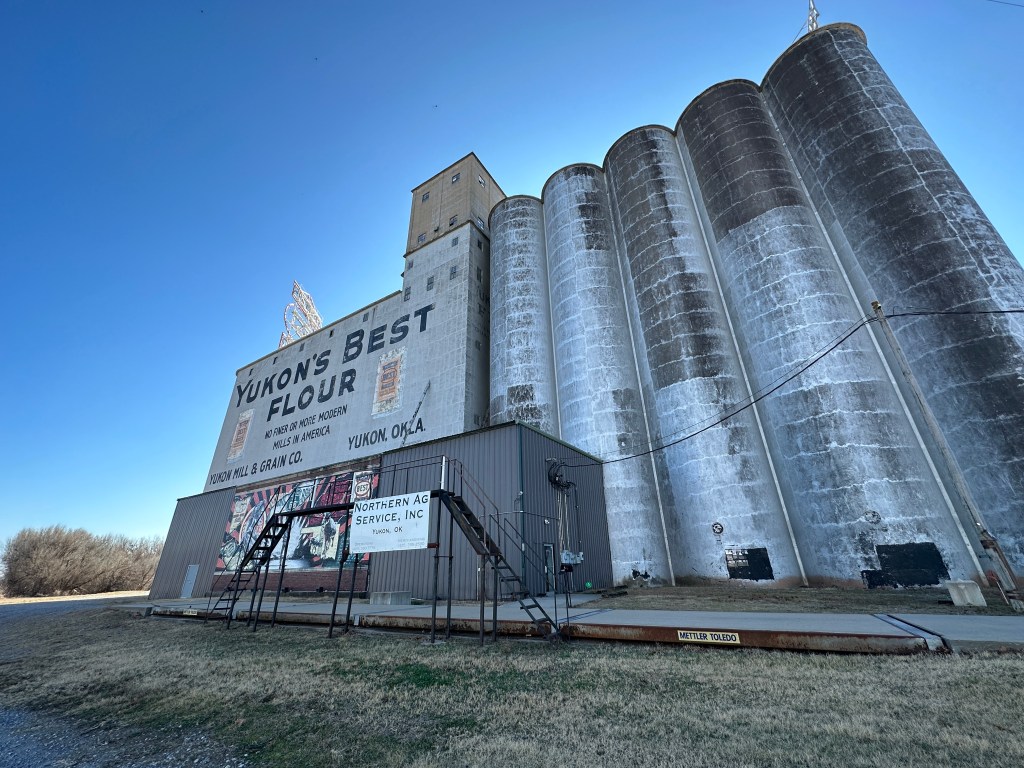 Historic Yukon Flour Mill exterior featuring silos and a sign that reads 'Yukon's Best Flour'.