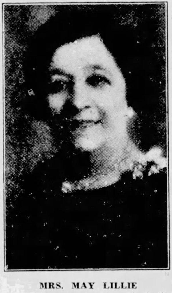 Black and white portrait of a woman named Mrs. May Lillie, smiling and looking directly at the camera.