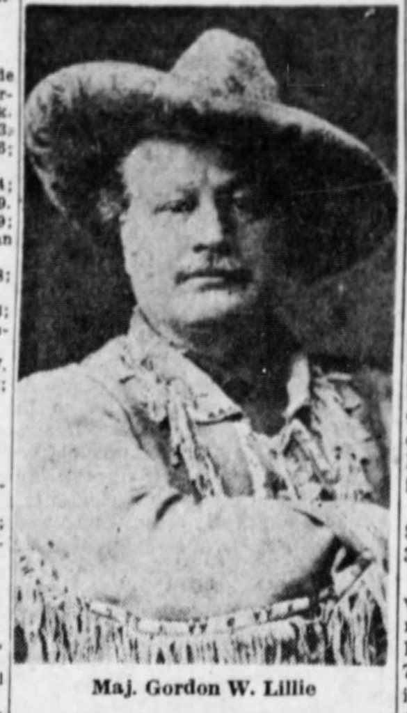 A historical black and white portrait of a man wearing a large hat and a fringed jacket, identified as Maj. Gordon W. Lillie.