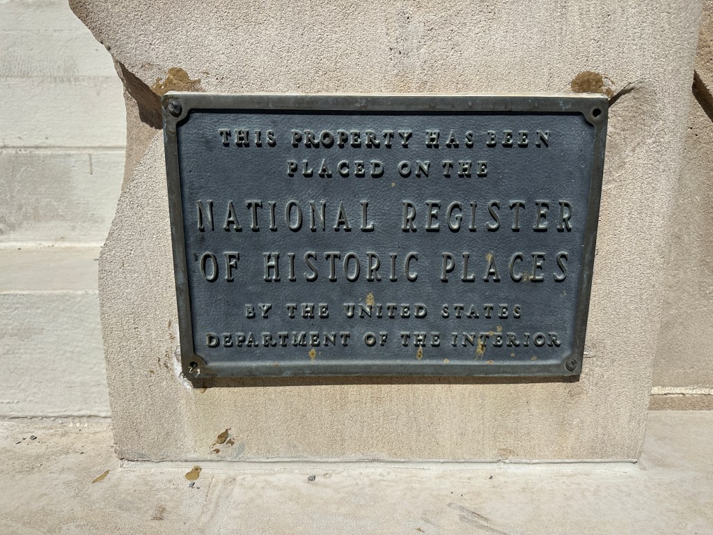 A metal plaque indicating that the property has been placed on the National Register of Historic Places by the United States Department of the Interior.